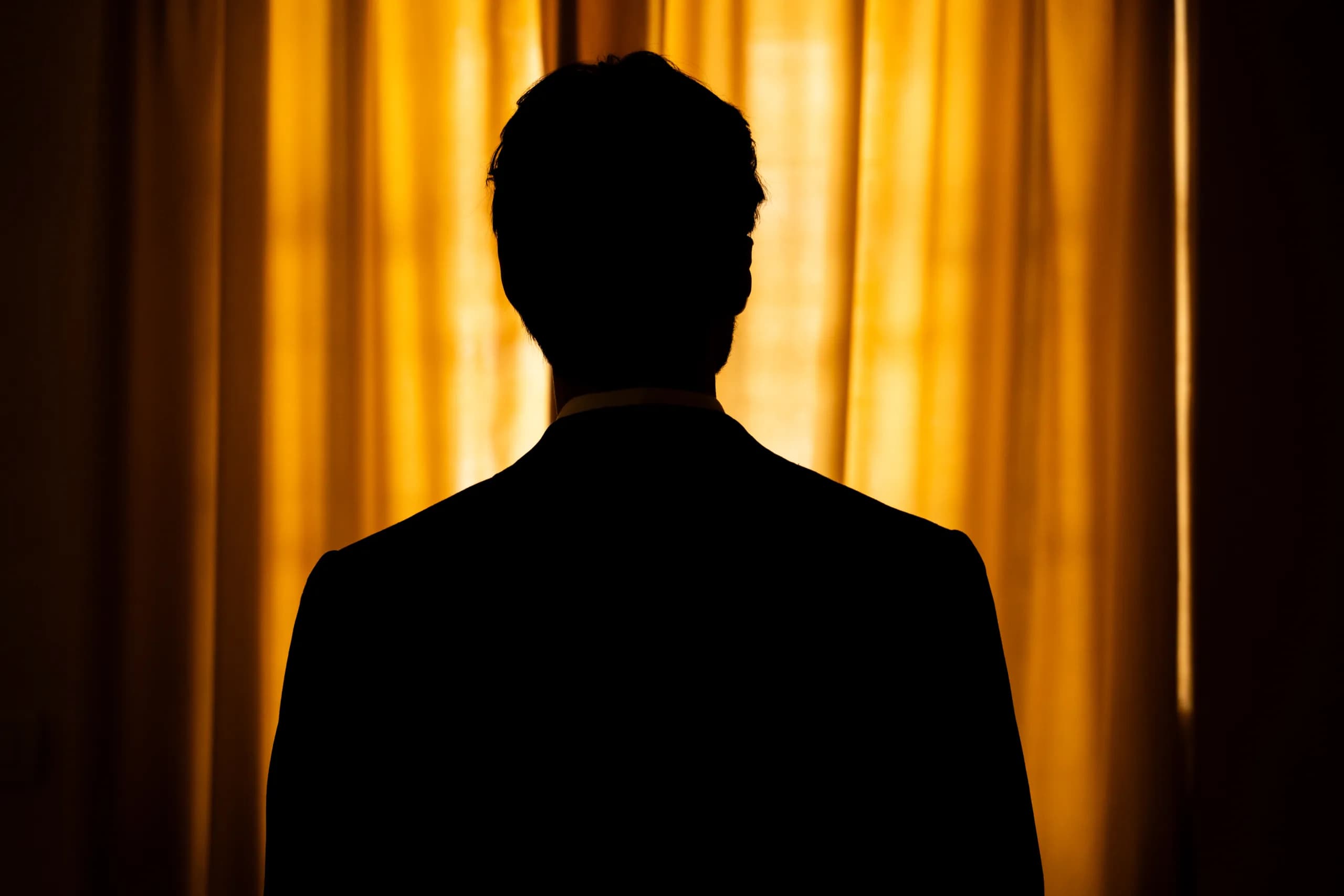 The groom isolated in the shadows of the sealed room